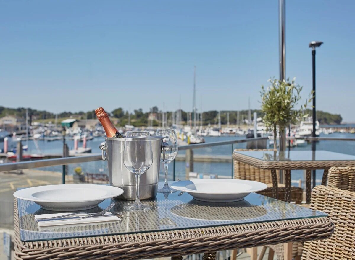 Champagne on ice and wine glasses on a table at The Terrace restaurant overlooking Yarmouth harbour and the Solent